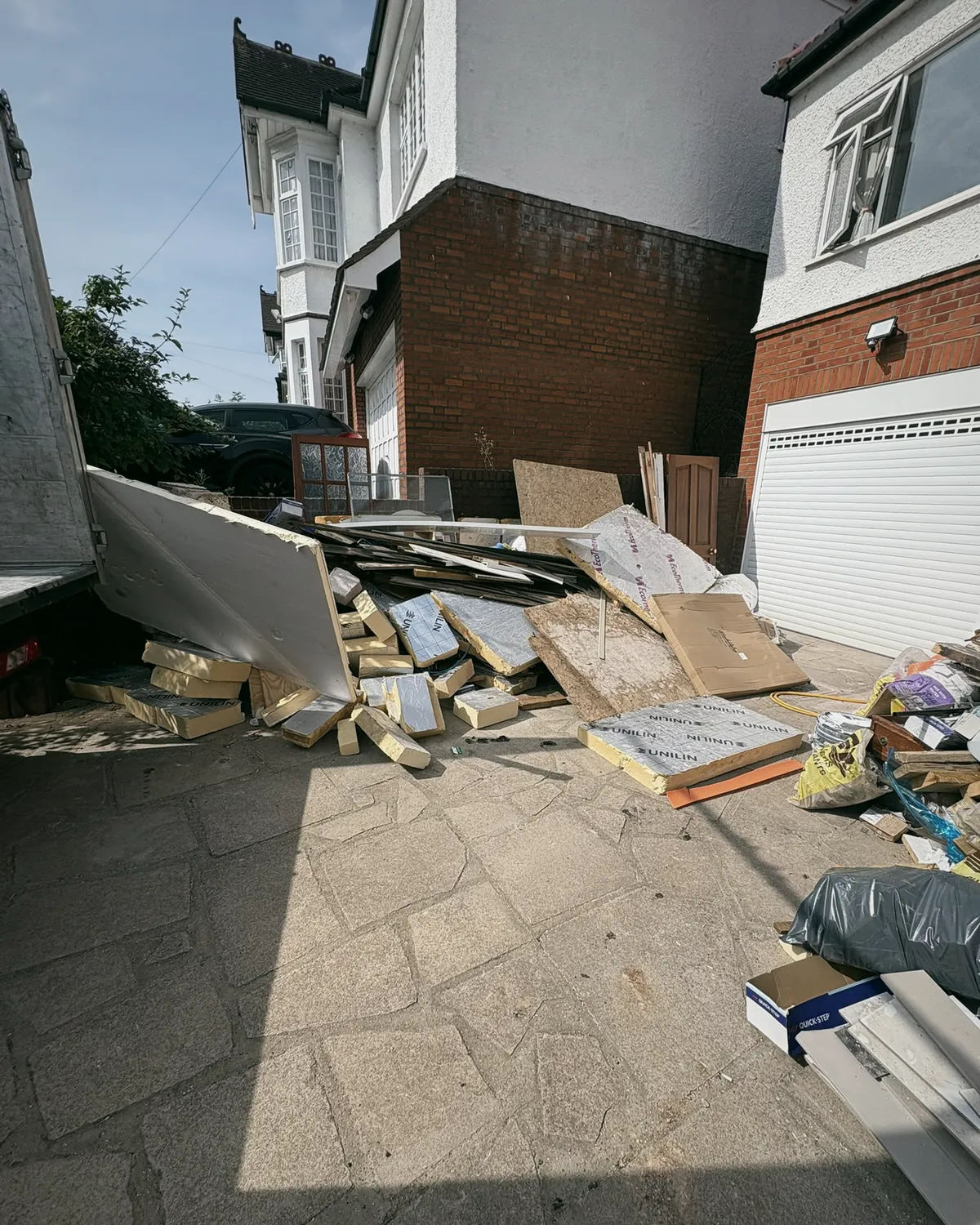 Building waste being loaded from a driveway onto the tail lift of the truck
