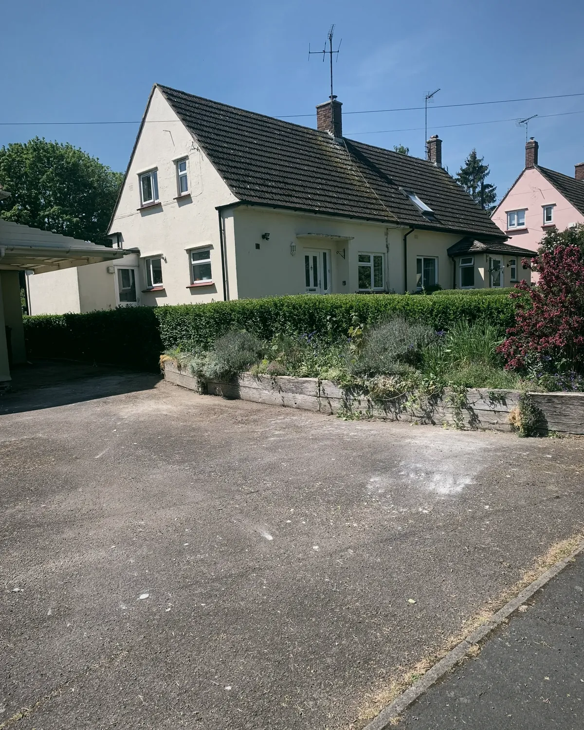 A semi detached house with its front drive cleared and swept