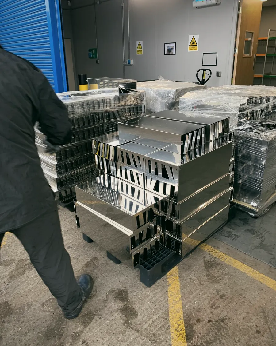 Stacked metal frames being carried across a commercial unit during a strip out