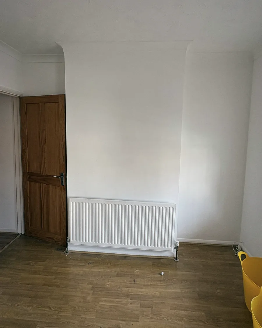 An empty room after a clearance, the door, radiator and floor bare