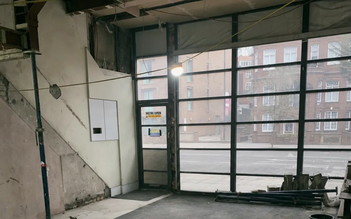 A shop unit after a strip out, swept bare behind its glazed shopfront