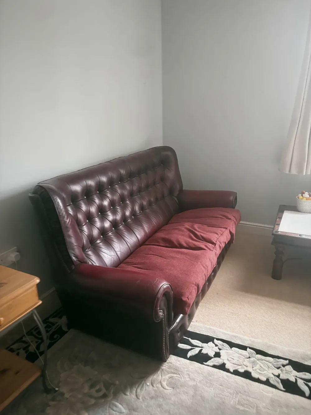 Before: A leather chesterfield and side furniture still in place on the rug.