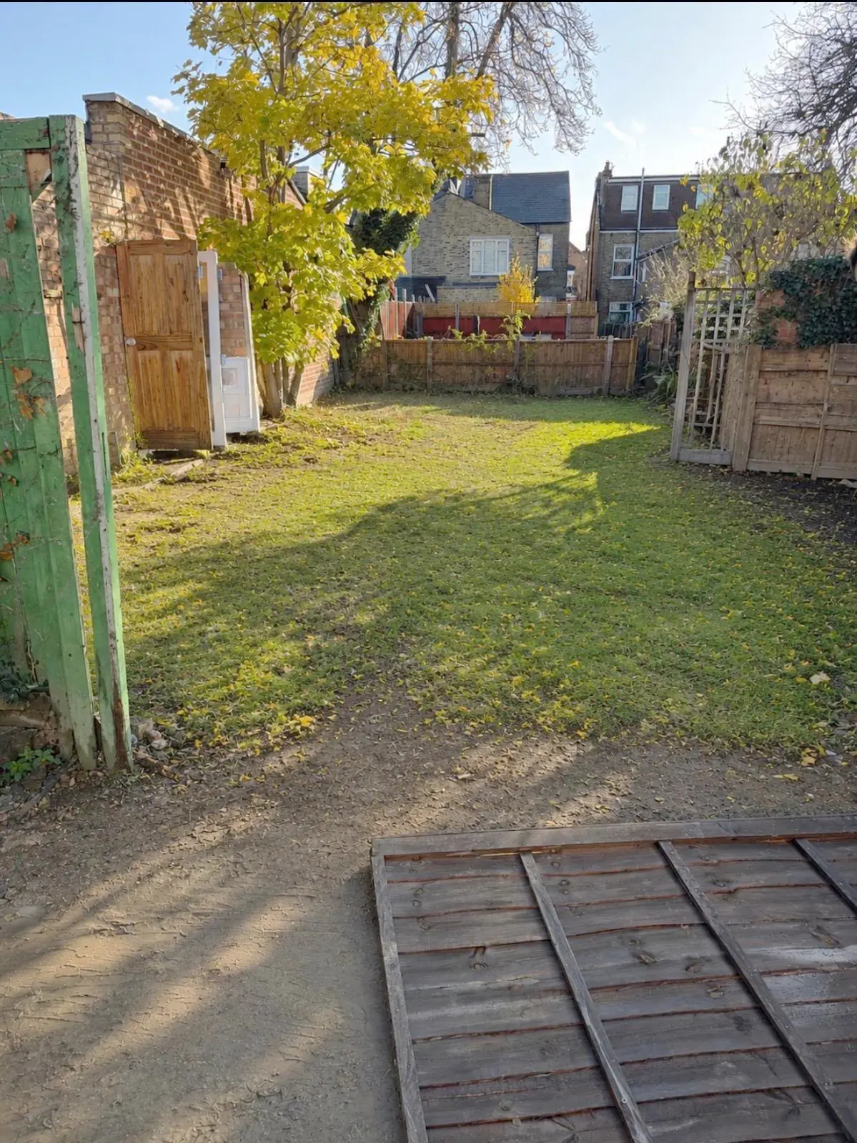 After. Garden cleared and cut, the fence panels stacked flat and the ground clear.