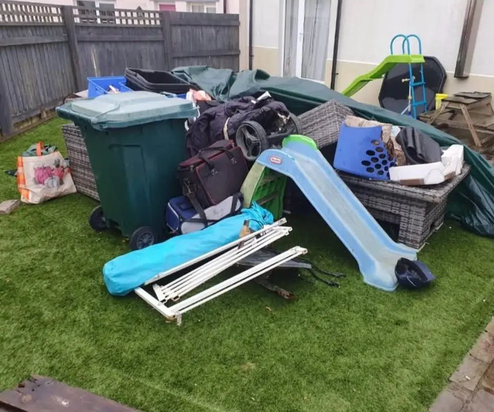Before. Bins, garden furniture, a collapsed gazebo and children's toys heaped across the lawn.