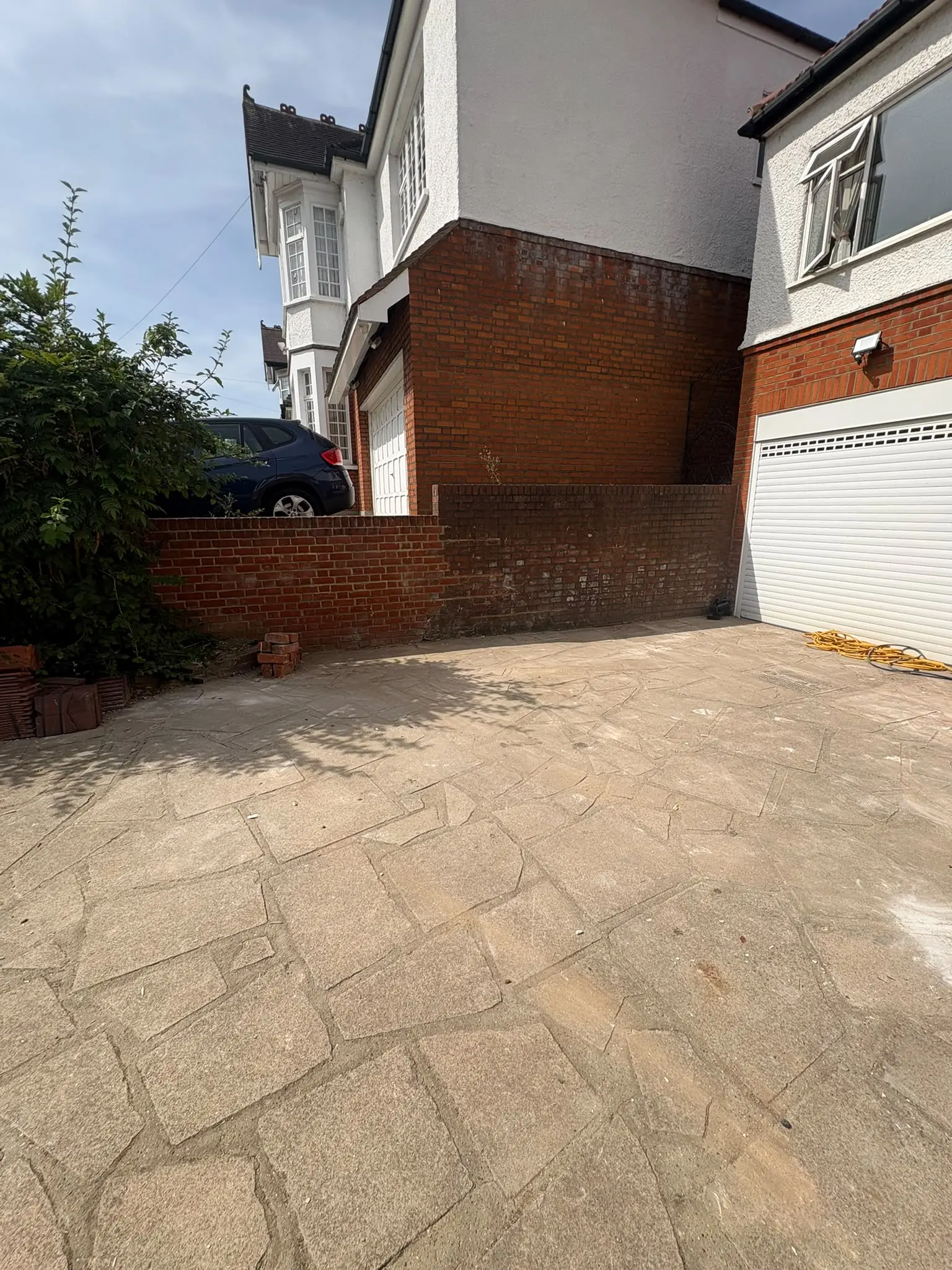 After. Passage and patio cleared and swept, back to the brick and the paving.