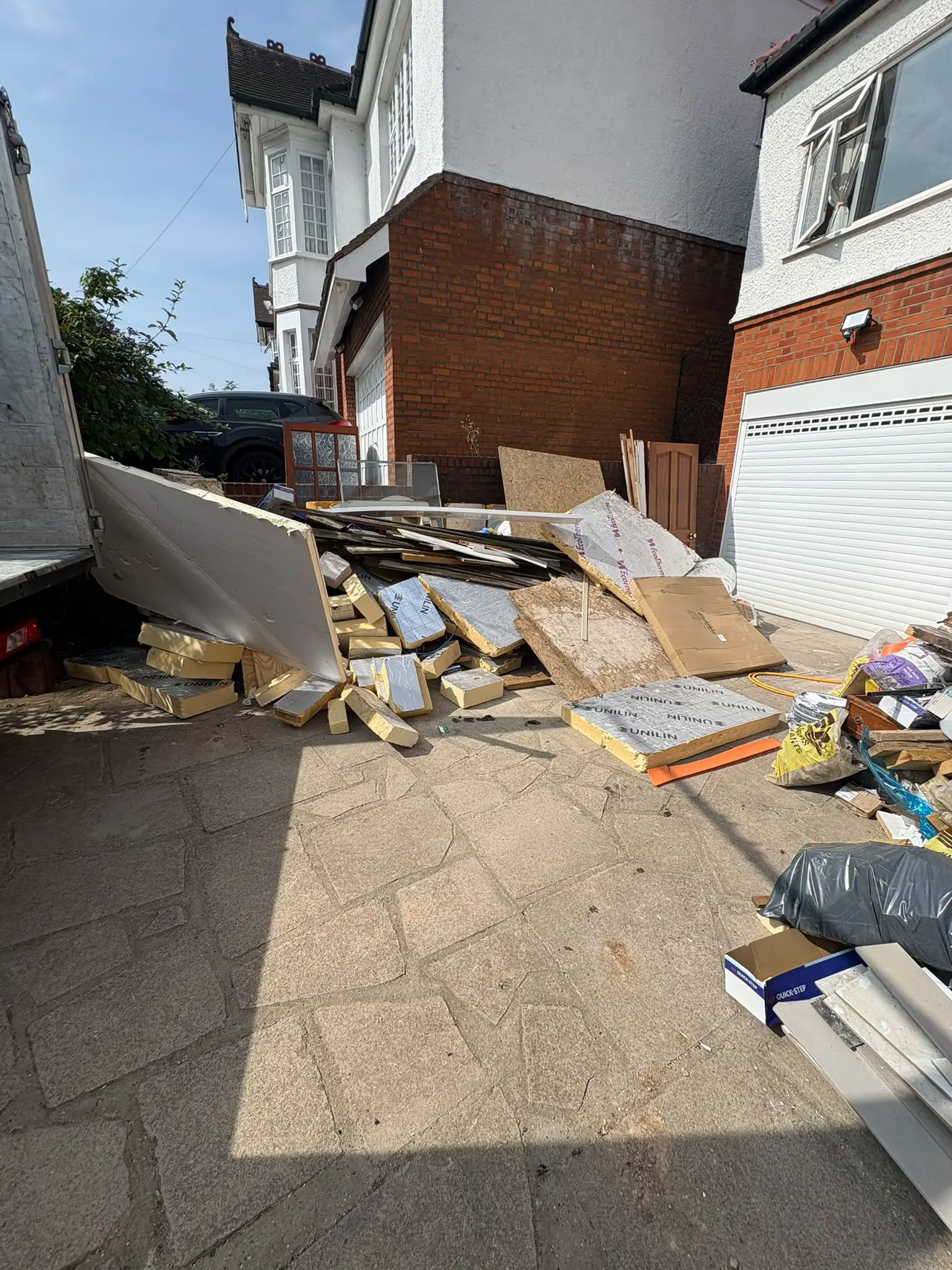 Before. Plasterboard, timber and cardboard stacked the length of the passage after a rip-out.