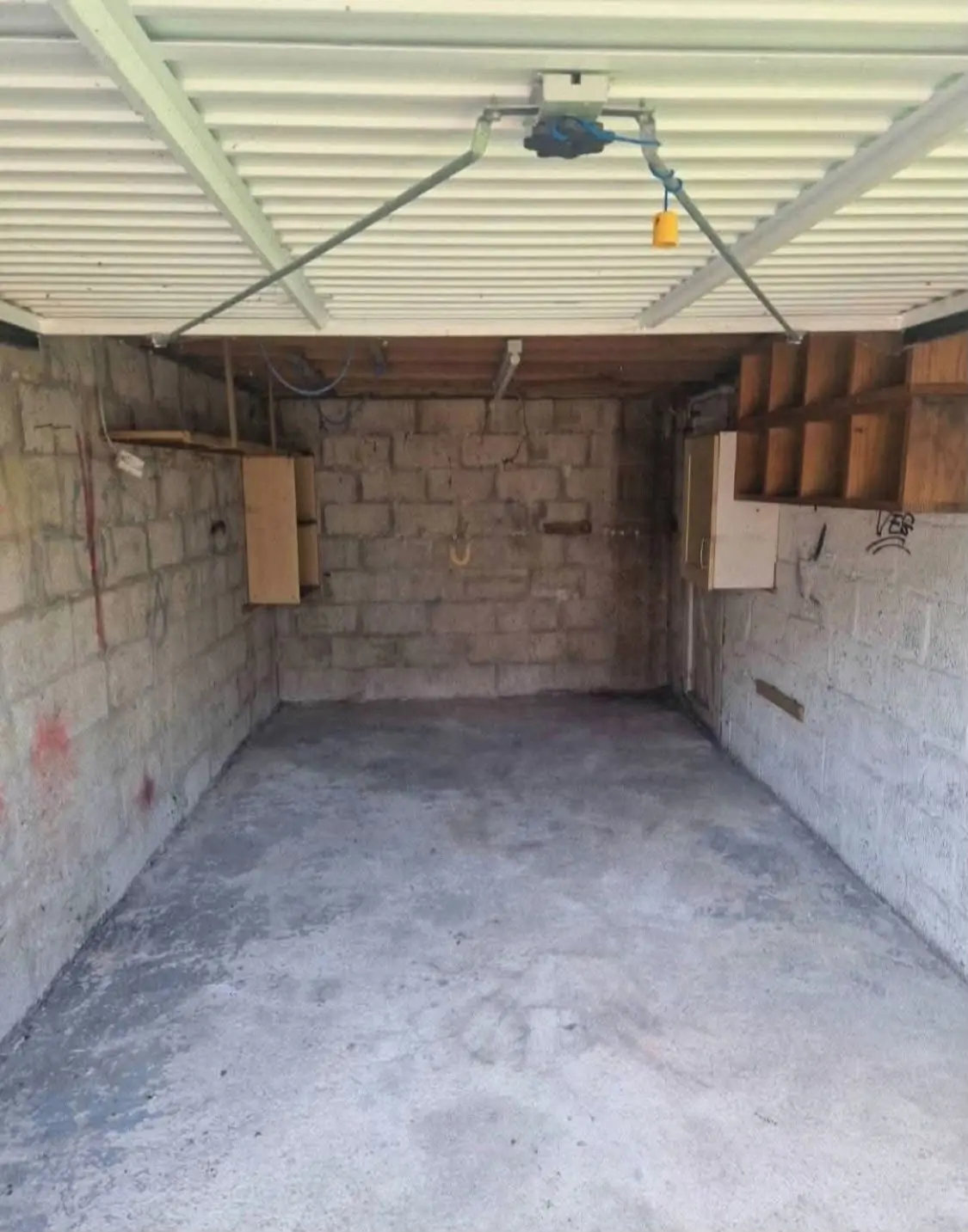 After. Swept concrete floor and bare block walls.