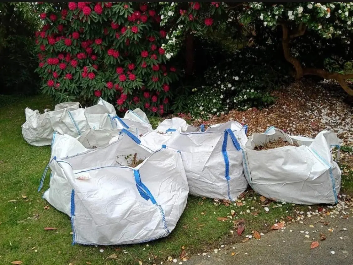 Before. Six bulk bags of garden waste sitting on the lawn.