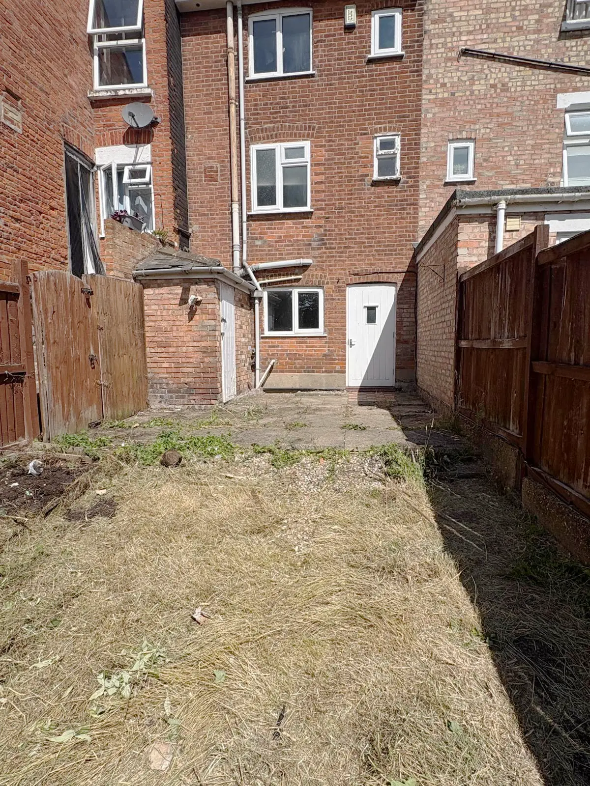 After. Cut back and cleared to bare earth, the full width of the garden usable.