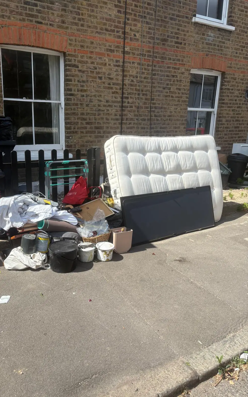 Before. A mattress, a television, pots, bags and a vacuum out on the pavement ready to go.