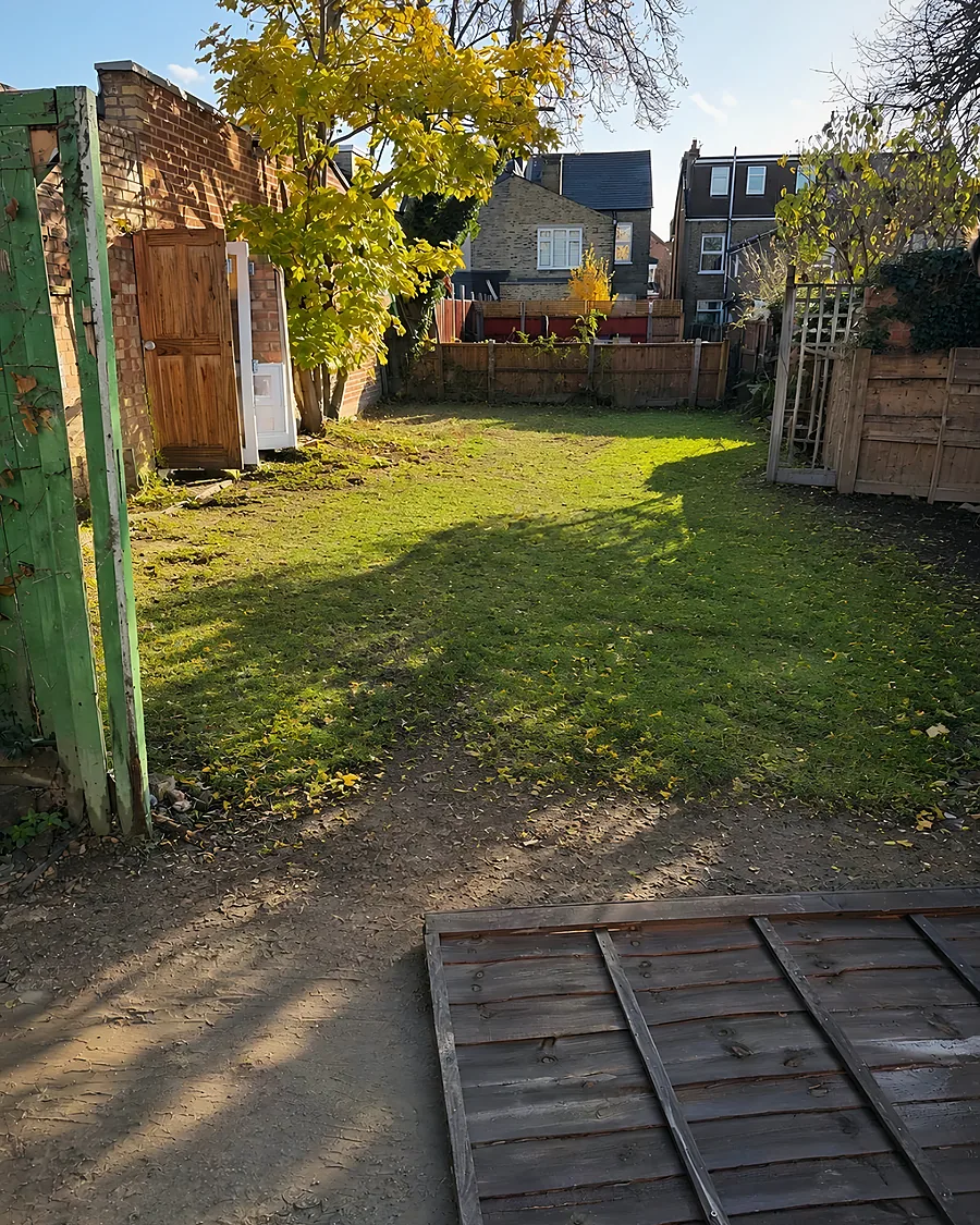 After: Garden cleared and cut, the fence panels stacked flat and the ground clear.