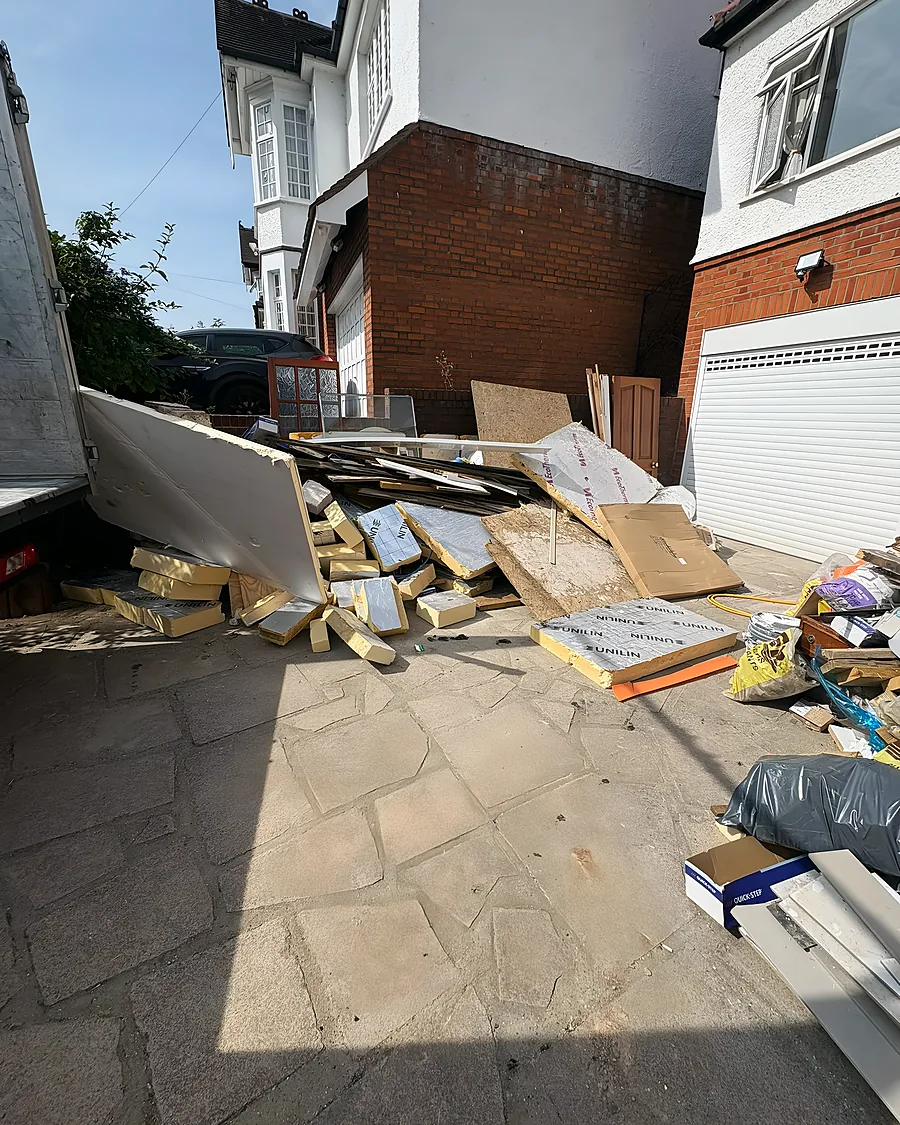 Before: Plasterboard, timber and cardboard stacked the length of the passage after a rip-out.