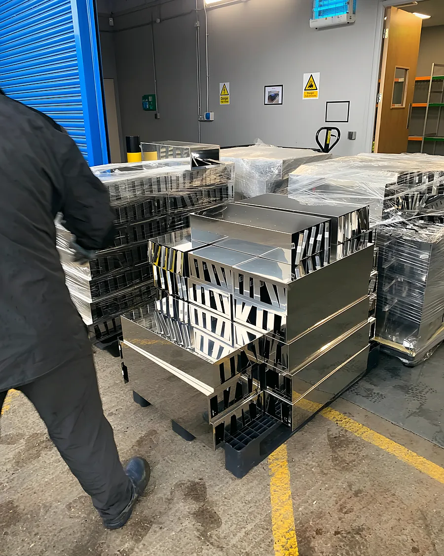 Stacked aluminium window frames being carried into a commercial unit