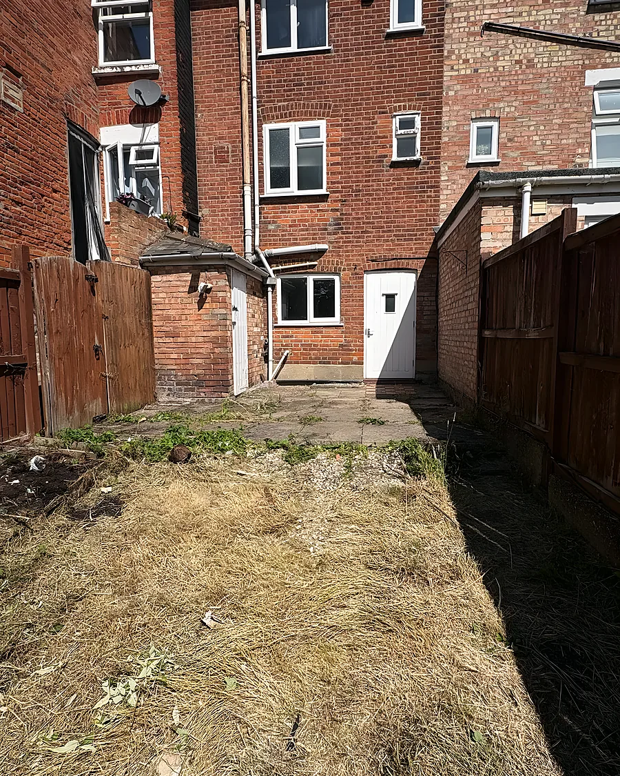 The same garden strimmed back to bare earth and cut grass