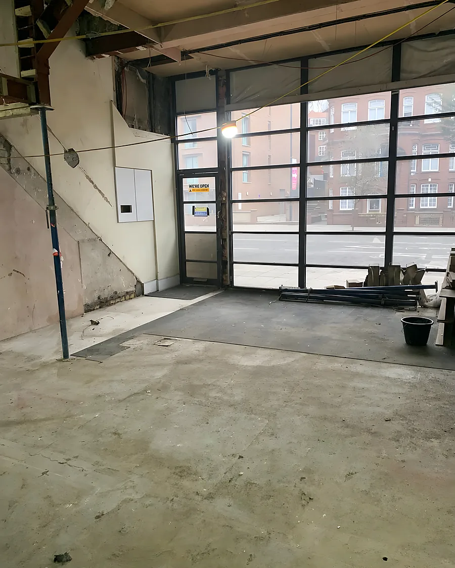 A shop unit after a strip out, swept bare behind its glazed shopfront