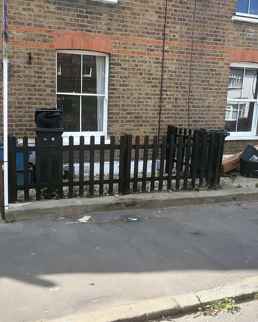 A brick terraced house, its front garden cleared to the paving after a clearance
