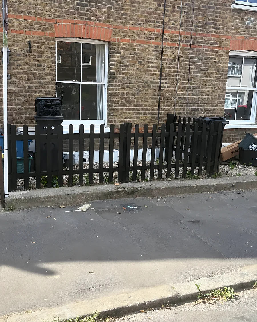 A brick terraced house, its front garden cleared to the paving after a clearance