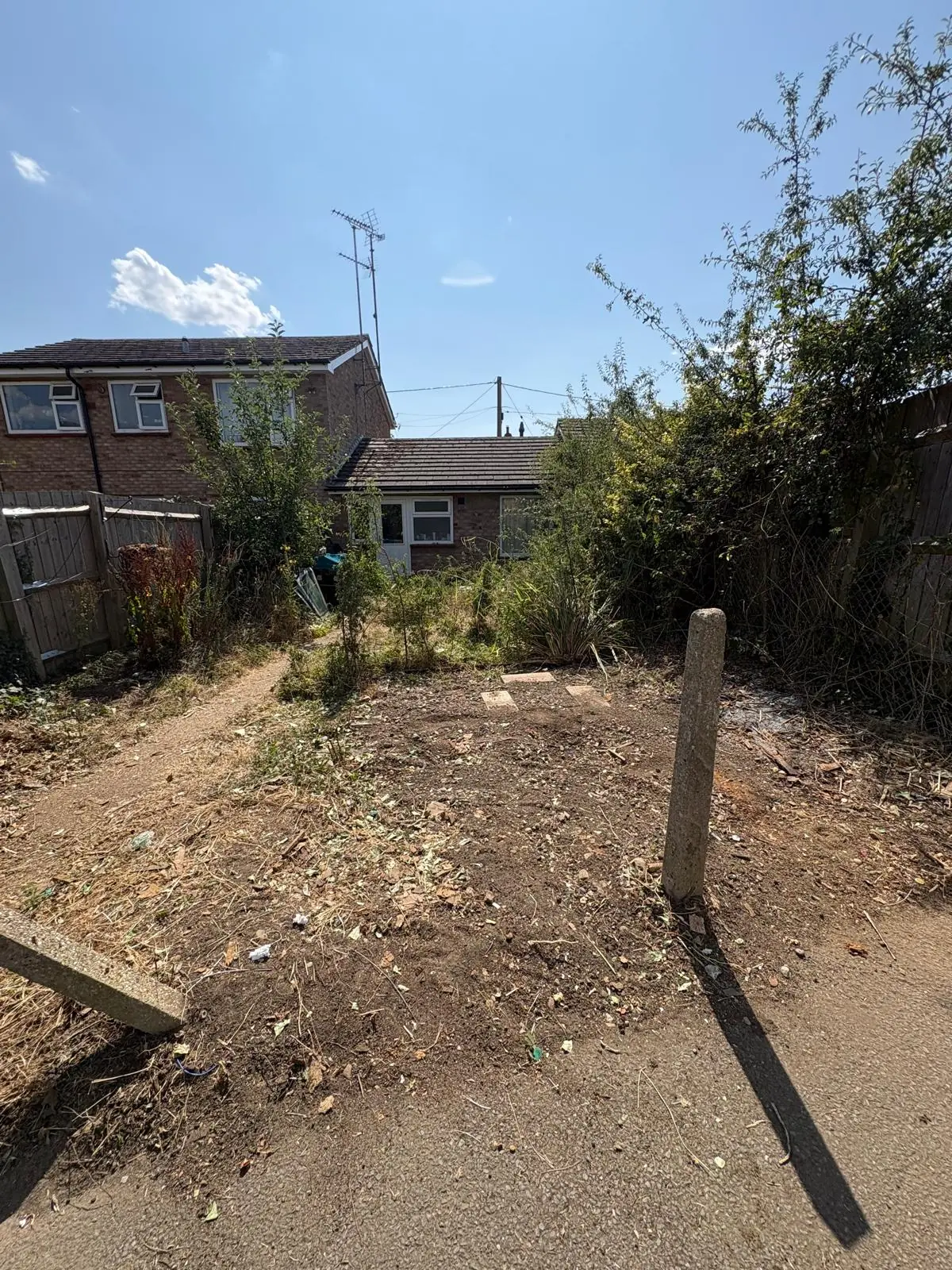 After. The same plot with the outbuilding gone and bare earth where it stood